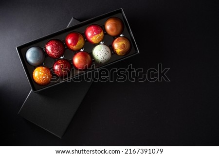 Open gift box with assortment of homemade chocolate bonbons. Modern hand painted chocolate candy. Product concept for chocolatier Royalty-Free Stock Photo #2167391079