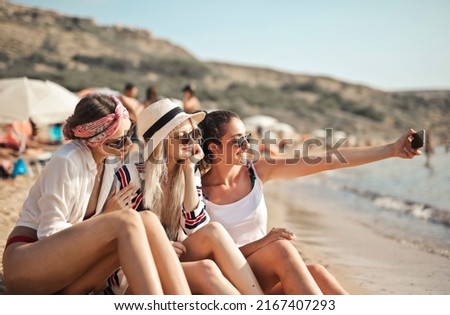 three girls on the beach take a selfie