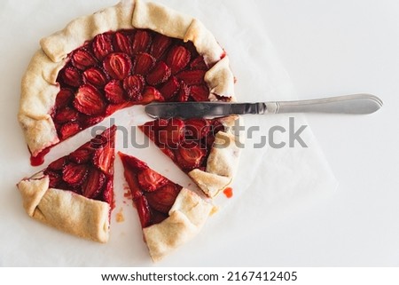 Pieces of homemade strawberry galette pie on white table. Top view