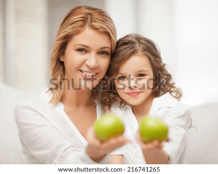 picture of mother and daughter with green apples