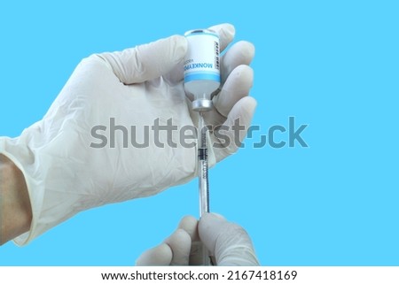 Monkeypox vaccine in researcher hands. Cropped view of the female doctor holds syringe and bottle with vaccine for monkeypox cure. Concept of monkeypox treatment, injection, shot and clinical trial Royalty-Free Stock Photo #2167418169