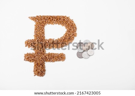 Top view of ruble sign formed of wheat seeds and rouble coins isolated on white. Wheat deficit, crisis and high prices concept
