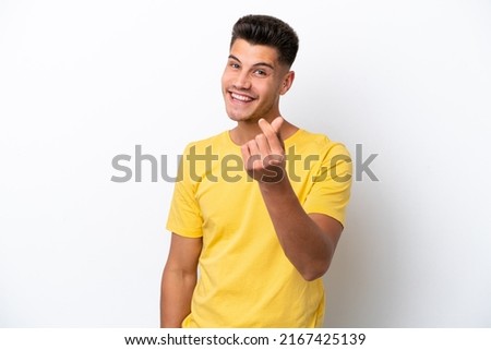 Young caucasian man isolated on white background making money gesture