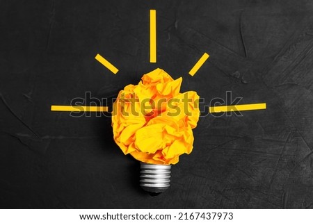 Lightbulb symbol made from a crumpled paper ball and a bulb base. Idea generation concept.