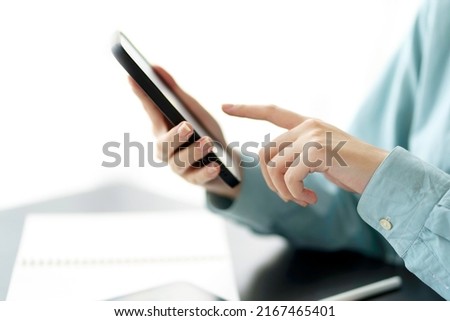 Closeup image of female using smartphone to send text , work or play social media.
