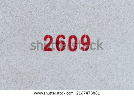 Red Number 2609 on the white wall. Spray paint.
