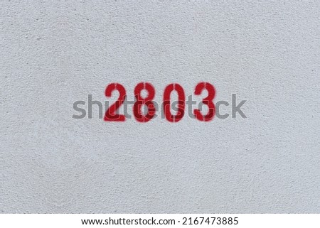 Red Number 2803 on the white wall. Spray paint.
