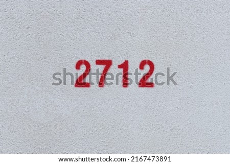 Red Number 2712 on the white wall. Spray paint.
