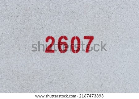 Red Number 2607 on the white wall. Spray paint.
