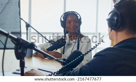 Female Host Talking to a Guest Friend on a Podcast Radio Station in the Studio. African American and European Record Podcast and Discuss Social Issues, Business Radio Show.