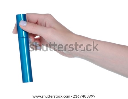 Hand holding mascara in blue tube on white background isolation