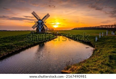 Mill by the river at dawn. Windmill at dawn. Beautiful sunrise over windmill farm. Mill on river at dawn Royalty-Free Stock Photo #2167490981