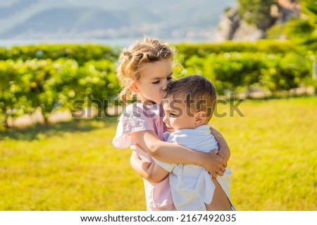 Portrait of two cute adorable baby children toddlers hugging and kissing each other, love friendship in childhood concept, best friends forever