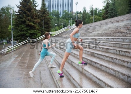  Women's fitness running training. Two woman jogging together up steprs in urban park in morning. wellness concept. . Healthy lifestyle fitness sports
