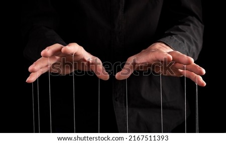 Man hands with strings at fingers. Manipulator controlling, exploiting person, showing power in relationship, at work. Dictatorship. High quality photo Royalty-Free Stock Photo #2167511393