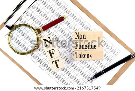 NFT text on a wooden block on chart background