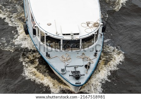 The bow of the ship's hull is a top view. The boat is moving on the water. Background picture.