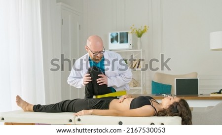 The Physical Therapist Evaluates the Condition and Suggests Appropriate Treatment to Relieve the Patient's Pain. Physiotherapy Treatment in the Modern Rehabilitation Clinic Royalty-Free Stock Photo #2167530053