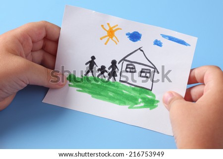 Child holds a drawn house with family.