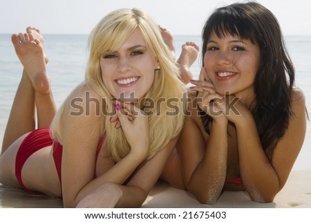 two beautiful girls lying on the beach in Hawaii smiling