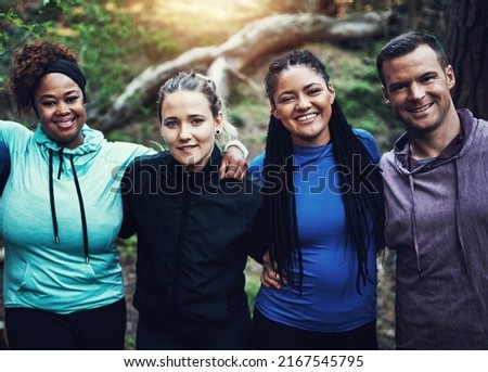 Some fresh air and great friends coming together to workout. Portrait of a group of sporty young friends standing in a row while working out in the forest.
