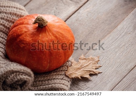 ripe orange pumpkins on a wooden table with autumn leaf, cozy autumn rustic still life with pumpkin