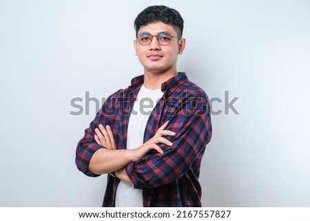 Young handsome man wearing casual shirt over white background happy face smiling with crossed arms looking at the camera. positive person.