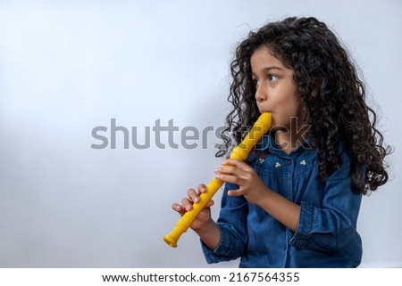 Latin American girl playing with skill the soprano recorder Royalty-Free Stock Photo #2167564355