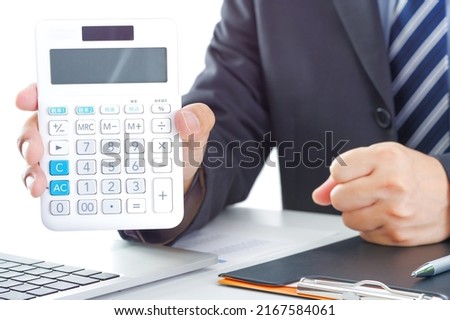 A man in a suit with a calculator Royalty-Free Stock Photo #2167584061