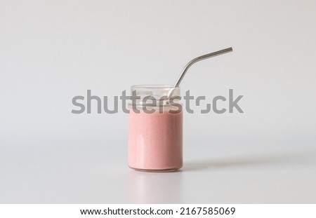 Close up of strawberry smoothie in glass jar with metal straw on neutral background (selective focus) Royalty-Free Stock Photo #2167585069