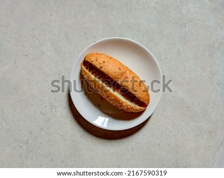 Photograph of close up hot dog on a white plate. Top view. Fit for advertisement, promotion, cook book recipe, cafe menu book, food magazine, etc.