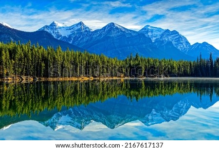 Reflection of mountain peaks in lake water. Mountain lake landscape. Mountain lake water reflection. Lake in mountain forest Royalty-Free Stock Photo #2167617137