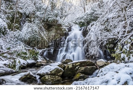 Waterfall in the winter forest. Snowy winter forest waterfall. Waterfall in winter snow forest. Winter waterfall landscape Royalty-Free Stock Photo #2167617147