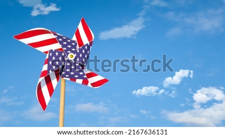 Pinwheel or windmill with USA flag as texture against bright blue sky. American's happiness concept. Royalty-Free Stock Photo #2167636131