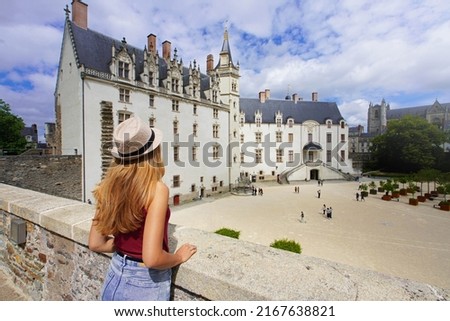 Tourist girl visiting the Château des ducs de Bretagne a large castle in the city of Nantes, France