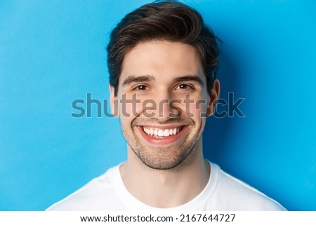 Head shot of handsome young man with beard, smiling happy over blue background. Copy space Royalty-Free Stock Photo #2167644727