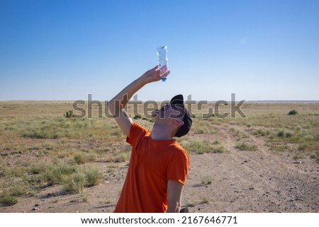 a man with an empty bottle in the desert. thirst. danger of dehydration. out of water Royalty-Free Stock Photo #2167646771