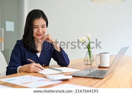 Professional and confident millennial asian businesswoman or executive manager sits at her office desk and working on her task.