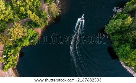 Top view of a white boat sailing in the blue sea. Top view of the boat. Aerial view luxury motor boat. A boat with a motor on blue water. High quality photo Royalty-Free Stock Photo #2167682503