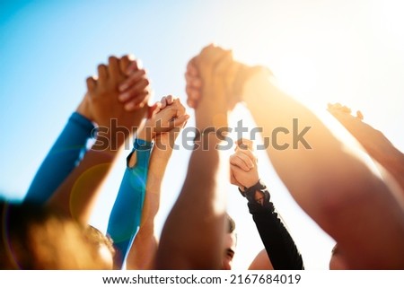 Lets stand together. Shot of a group of unrecognizable people holding hands together in the air. Royalty-Free Stock Photo #2167684019