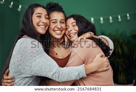 Were like a family of friends. Shot of three happy young sisters embracing at a cafe. Royalty-Free Stock Photo #2167684831