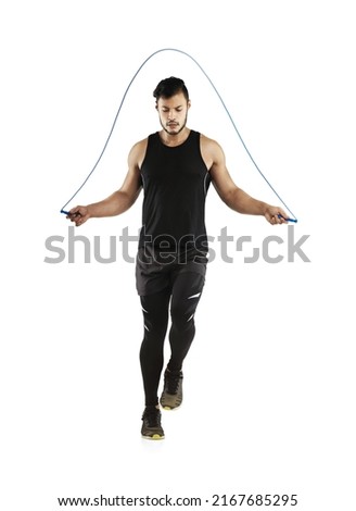 Getting his heart rate going. Studio shot of a young man skipping with a jump rope against a white background. Royalty-Free Stock Photo #2167685295