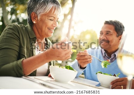 Healthiness and happiness go hand in hand. Shot of a happy older couple enjoying a healthy lunch together outdoors. Royalty-Free Stock Photo #2167685831