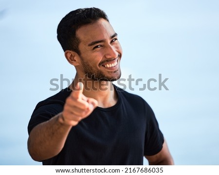 I know exactly what you need. Shot of a sporty young man smiling while standing outside. Royalty-Free Stock Photo #2167686035