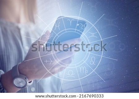 Woman with smartphone reading daily horoscope indoors, closeup Royalty-Free Stock Photo #2167690333