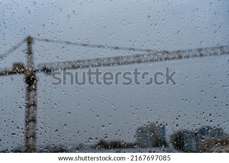 Raindrops on glass in cloudy rainy weather. Autumn bad weather concept.