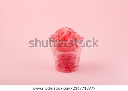 Fruit shaved ice in disposable plastic cup. Slushie - drink on pink background. Take away food. Refreshing summer drink. Royalty-Free Stock Photo #2167718979