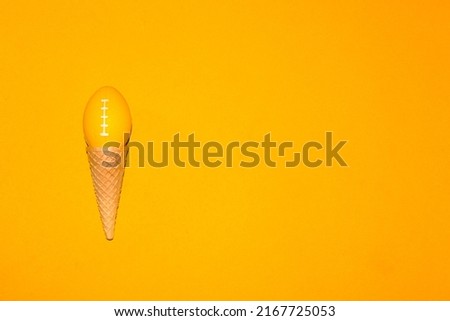 ice cream cone with ball for american football instead of ice cream ball, creative art design, slow ice cream on yellow background