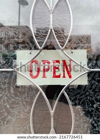 An open sign hanging on the entrance door of a small cafe. Small business concept