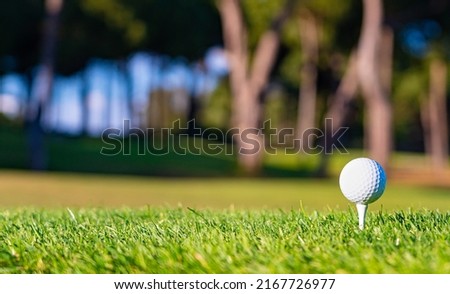 Golf ball on a tee on the grass before the first shot